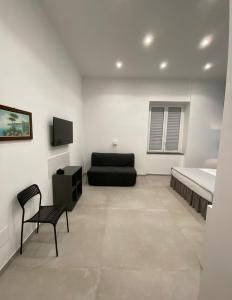 a bedroom with a bed and a couch and a chair at Partenope 10 in Naples