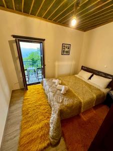 a bedroom with a large bed with a large window at Vradeto Guesthouse in Vradéton