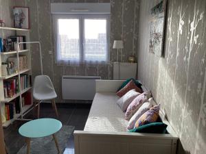 ein Zimmer mit einem Sofa mit Kissen darauf in der Unterkunft FABYANN in Marieulles