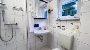 a bathroom with a sink and a toilet and a window at Fewo Graal in Graal-Müritz