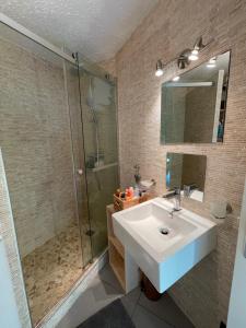 une salle de bain avec un lavabo blanc et une douche dans l'établissement Le repère de Bianca, le premier de cordée, à Montgenèvre 18 autres photos