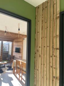 ein Esszimmer mit grünen Wänden und einer Glasschiebetür in der Unterkunft Le repère de Bianca, le premier de cordée in Montgenèvre