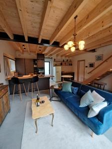 a living room with a blue couch and a table at Chez Rosé in Sainte-Cécile