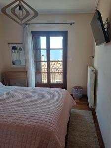 阿拉霍瓦的住宿－Ilias home Arachova，一间卧室设有一张床和一个大窗户
