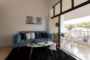a living room with a blue couch and a table at Flat Anchor Marine Monte Vista in Sosúa