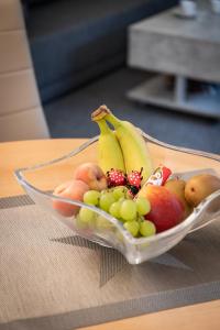 a bowl of fruit with bananas grapes and other fruits at Fewo Graal in Graal-Müritz