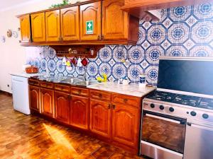 a kitchen with wooden cabinets and a stove at SwordFish Ocean View House in Peniche