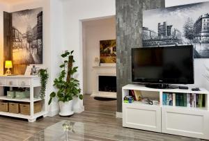 a living room with a television on a white entertainment center at Hinkelsgasser Südhang in Saarbrücken