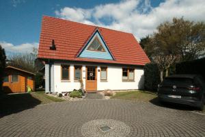シュタインフーデにあるFerienhaus Juleの赤屋根の小さな白い家
