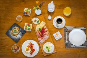 einen Tisch mit Tellern und einer Tasse Kaffee in der Unterkunft Pension Happy Superior in Špindlerův Mlýn