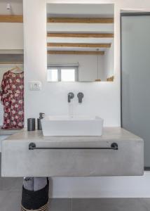 a bathroom with a sink and a mirror at Agia Kyriaki Studios in Agia Kiriaki Beach