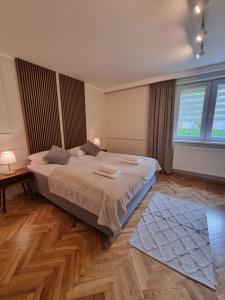 a bedroom with a large bed and a large window at Apartamenty 39 z pięknym ogrodem in Ustroń