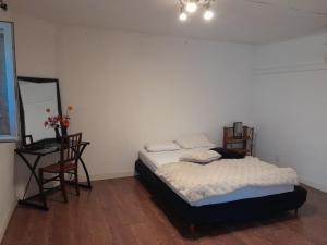 Un dormitorio con una cama, una mesa y una silla. en séjour au pays des Béarn, en Baigts-de-Béarn
