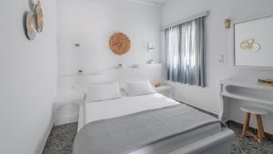 a white bedroom with a bed and a sink at Agia Kyriaki Studios in Agia Kiriaki Beach