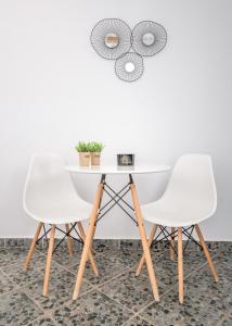 a table and two chairs in a room with a wall at Agia Kyriaki Studios in Agia Kiriaki Beach