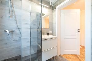 a bathroom with a shower and a sink at Apartamenty 39 z pięknym ogrodem in Ustroń
