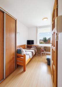 1 dormitorio con cama, escritorio y ventana en Dom Gościnny Relax, en Rewal