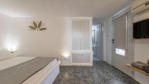 a bedroom with a bed and a flat screen tv at Agia Kyriaki Studios in Agia Kiriaki Beach