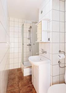 ein weißes Bad mit einem Waschbecken und einer Dusche in der Unterkunft Dom Gościnny Relax in Rewal