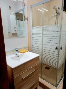 La salle de bains est pourvue d'un lavabo et d'une douche. dans l'établissement Angyal Apartman Gyula, à Gyula