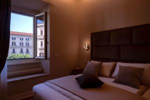 拿坡里的住宿－Domina-Boutique Apartment，一间卧室设有一张大床和一个窗户。