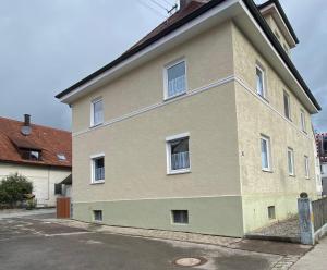 a large building with white windows on a street at Ferienzimmer Fischach in Fischach