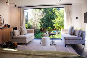a living room with two chairs and a large window at Paarl Hideaway in Paarl