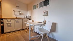 Guest House Dolomiti في باسيلغا دي بيني: مطبخ صغير مع طاولة و كرسيين