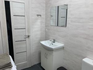 a white bathroom with a sink and a mirror at Anna’s dim in Uzhhorod