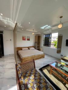 1 dormitorio con 2 camas, mesa y sofá en Big & confortable studio in Osu, en Accra