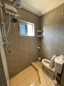 La salle de bains est pourvue d'une douche et de toilettes. dans l'établissement Big & confortable studio in Osu, à Accra