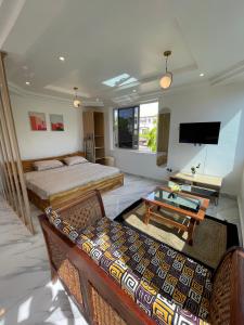 um quarto de hotel com duas camas e uma televisão em Big & confortable studio in Osu em Acra