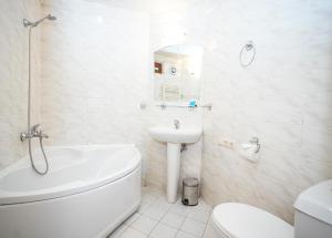 bagno bianco con lavandino, vasca e servizi igienici di Beaumonde Hotel Tbilisi a Tbilisi City Altre 34 foto