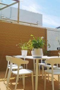 uma mesa e cadeiras com vasos de plantas num pátio em Suzhou MeetU Intl Youth Hostel em Suzhou