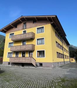 a yellow building with wooden balconies on it at Gästehaus Rudolfo in Zell am See