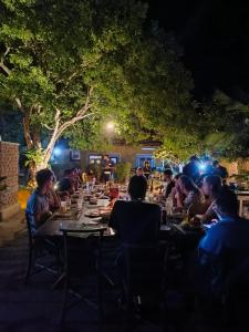 a group of people sitting at a table at night at Iora Resort Habarana in Habarana