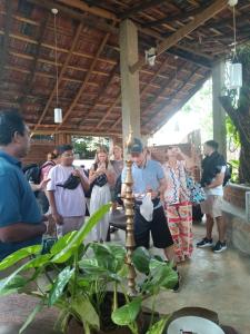 a group of people standing around a lighted candle at Iora Resort Habarana in Habarana