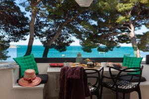 a table and chairs with a view of the ocean at Beach Apartment 'Hedonist' in Makarska
