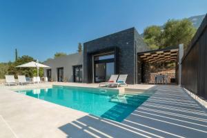a villa with a swimming pool and a house at Villa Vista Mare Lourdata Kefalonia in Lourdhata