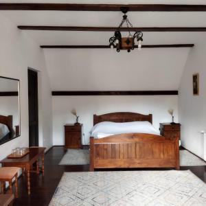 a bedroom with a wooden bed and a table at Zori de zi in Bran