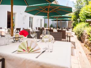 - une table avec des verres à vin et une fleur dans l'établissement Altmühlberg Hotel & Restaurant, à Beilngries