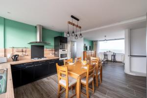 een keuken en eetkamer met een tafel en stoelen bij *Face à la mer* Malo-les-bains in Duinkerke