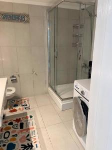 La salle de bains est pourvue d'une douche et d'un lave-linge. dans l'établissement Peacefull, Private, Pristine Studio Apartment, à Bodrum City