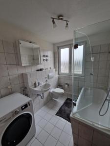 y baño con bañera, lavabo y aseo. en FEWODAYs Ferienwohnung in Sassnitz - Ruegen, en Sassnitz