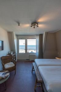 デ・コーフにあるStrandhotel Noordzeeのベッド付きのホテルルームで、海の景色を望めます。