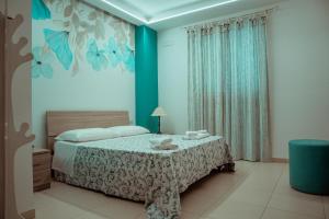 a bedroom with a bed with a blue wall at Massanè Casa Vacanza in Ginosa