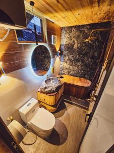 Làng Cac的住宿－Chien's Lodge Du Gia，一间带卫生间和石墙的浴室