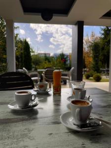 a table with three cups of coffee on it at Hotel sofra in Ferizaj