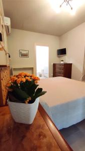 a bedroom with a bed and a vase of flowers at Gli Ulivi Rooms in Lucca