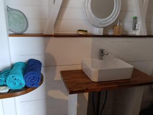 a bathroom with a sink and a mirror and towels at TI KAZ ANOLI Cottage en bois avec vue sur la baie in Terre-de-Bas